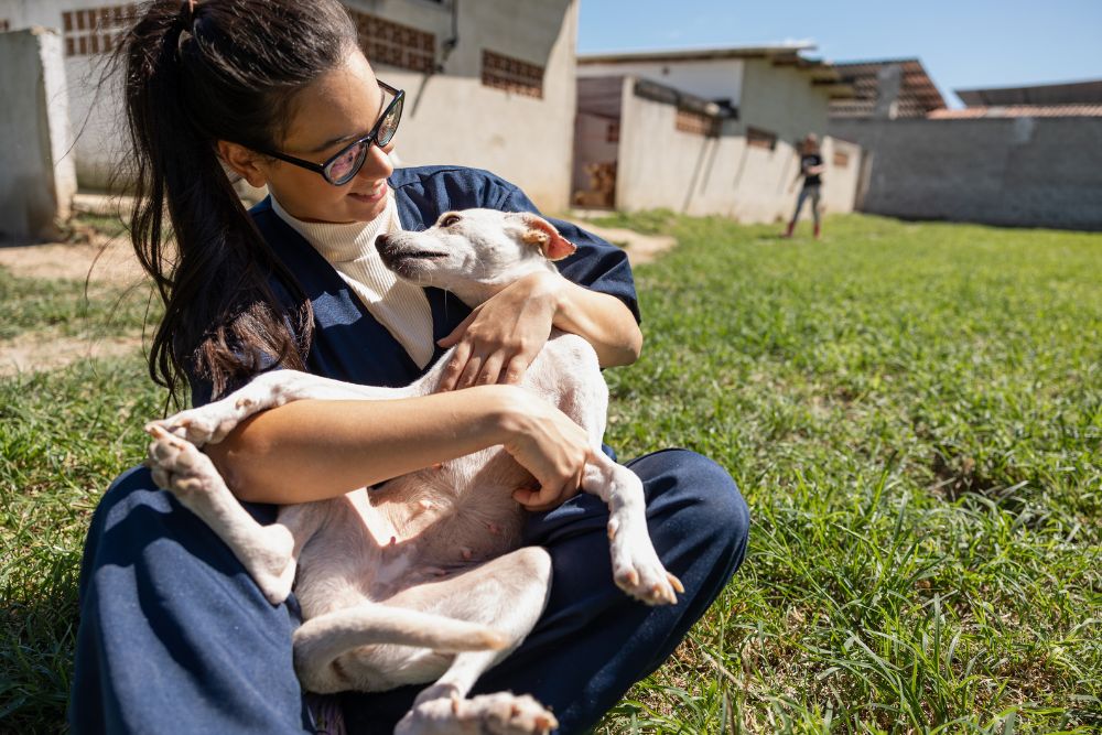 Woman holds small dog outside